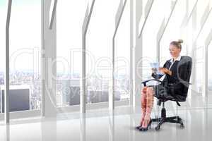 Composite image of businesswoman sitting on swivel chair with ta