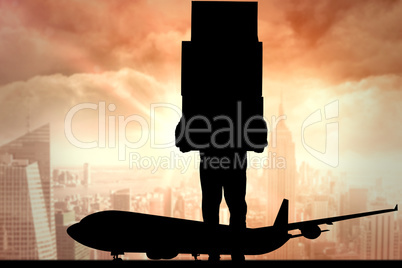 Composite image of delivery man carrying stacked boxes