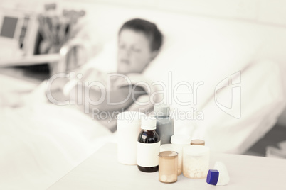 Medicines on table with boy in bed