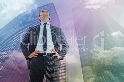 Composite image of happy businessman with hands on hips