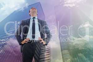 Composite image of happy businessman with hands on hips