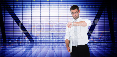 Composite image of serious businessman holding laptop checking t