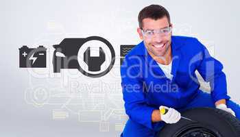 Composite image of portrait of happy mechanic working on tire