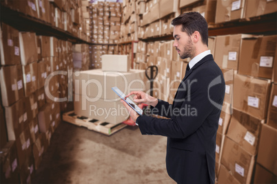 Composite image of concentrated businessman touching his tablet