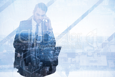 Composite image of businessman using laptop while phoning