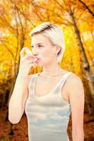 Composite image of blonde woman taking her inhaler