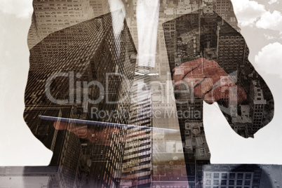 Composite image of businessman looking at his tablet through mag