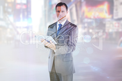 Composite image of serious charismatic businessman holding a tab