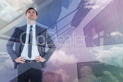 Composite image of serious businessman with hands on hips