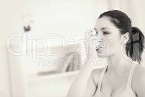 Woman using asthma inhaler in living room