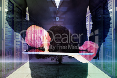 Composite image of businessman using his tablet pc