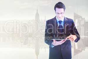 Composite image of businessman standing while using a tablet pc