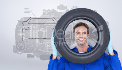 Composite image of confident mechanic looking through tire