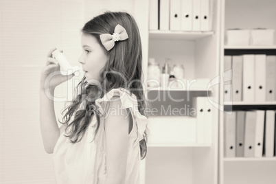 Little girl taking inhaler