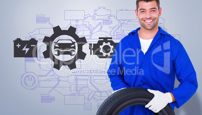 Composite image of mechanic holding tire on white background