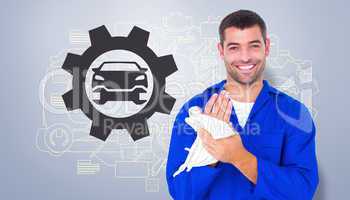 Composite image of male mechanic wiping hands with cloth