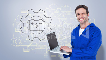 Composite image of handsome mechanic using laptop over white bac