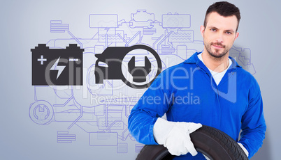 Composite image of smiling male mechanic holding tire