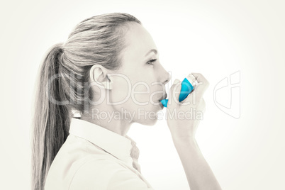 Pretty blonde using an asthma inhaler