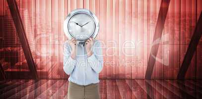 Composite image of businesswoman in suit holding a clock