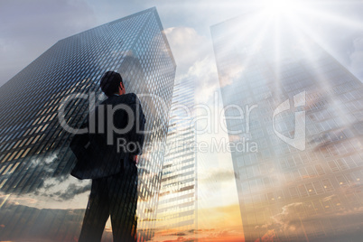 Composite image of businessman standing with hands on hips