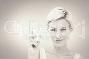 Composite image of pretty woman holding inhaler smiling at camer