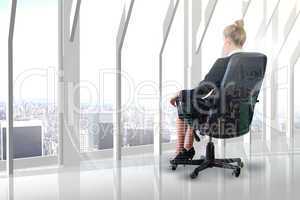 Composite image of businesswoman sitting on swivel chair in blac