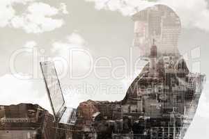 Composite image of businessman using laptop