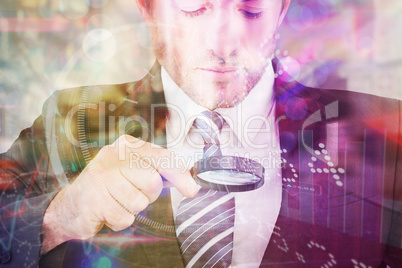 Composite image of businessman looking at tablet with magnifying