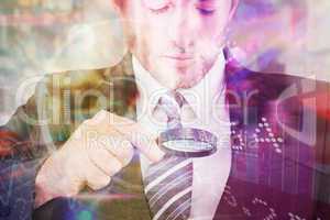 Composite image of businessman looking at tablet with magnifying