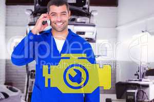 Composite image of portrait of smiling male mechanic using mobil