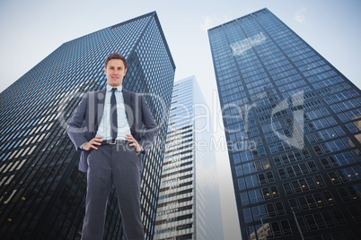 Composite image of happy businessman with hands on hips