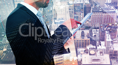 Composite image of businessman using his tablet pc