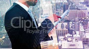 Composite image of businessman using his tablet pc