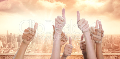 Composite image of hands up and thumbs raised