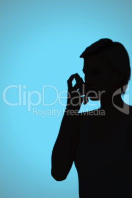 Composite image of blonde woman taking her inhaler