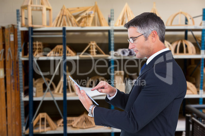 Composite image of mid section of a businessman touching tablet