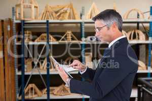 Composite image of mid section of a businessman touching tablet