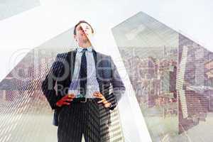 Composite image of happy businessman with hands on hips