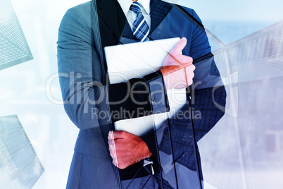 Composite image of businessman holding his laptop tightly