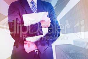 Composite image of businessman holding his laptop tightly