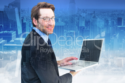 Composite image of smiling businessman using a laptop