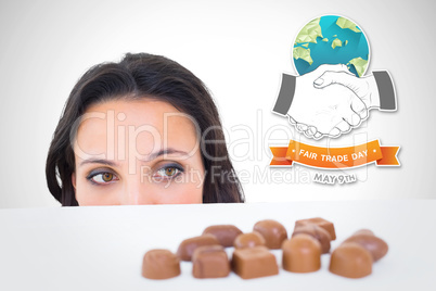 Composite image of pretty brunette peeking at chocolate