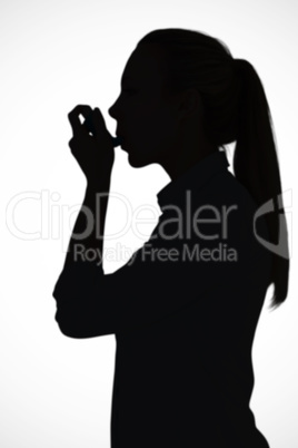 Composite image of beautiful blonde using an asthma inhaler