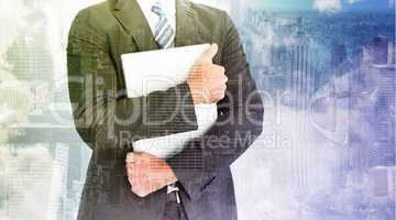 Composite image of businessman holding his laptop tightly