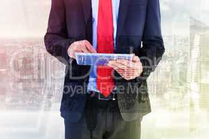 Composite image of businessman scrolling on his digital tablet