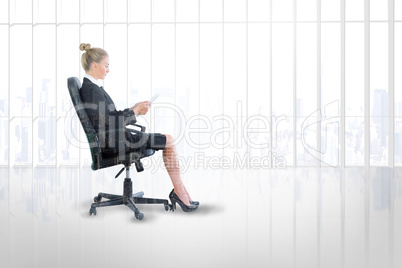 Composite image of businesswoman sitting on swivel chair with ta