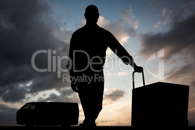 Composite image of confident delivery man with cardboard boxes