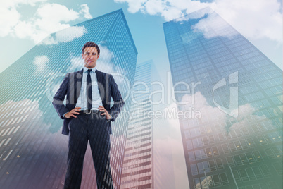 Composite image of happy businessman with hands on hips