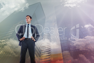 Composite image of serious businessman with hands on hips